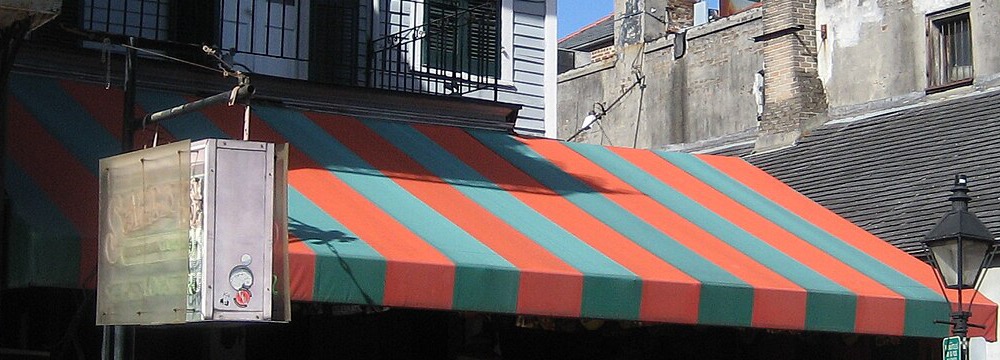 A red and green striped awning over a restaurant terrace